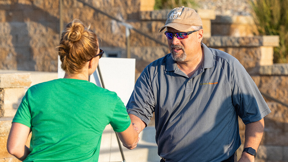 Henderson Engineers employee greeting a client at the client golf tournament.