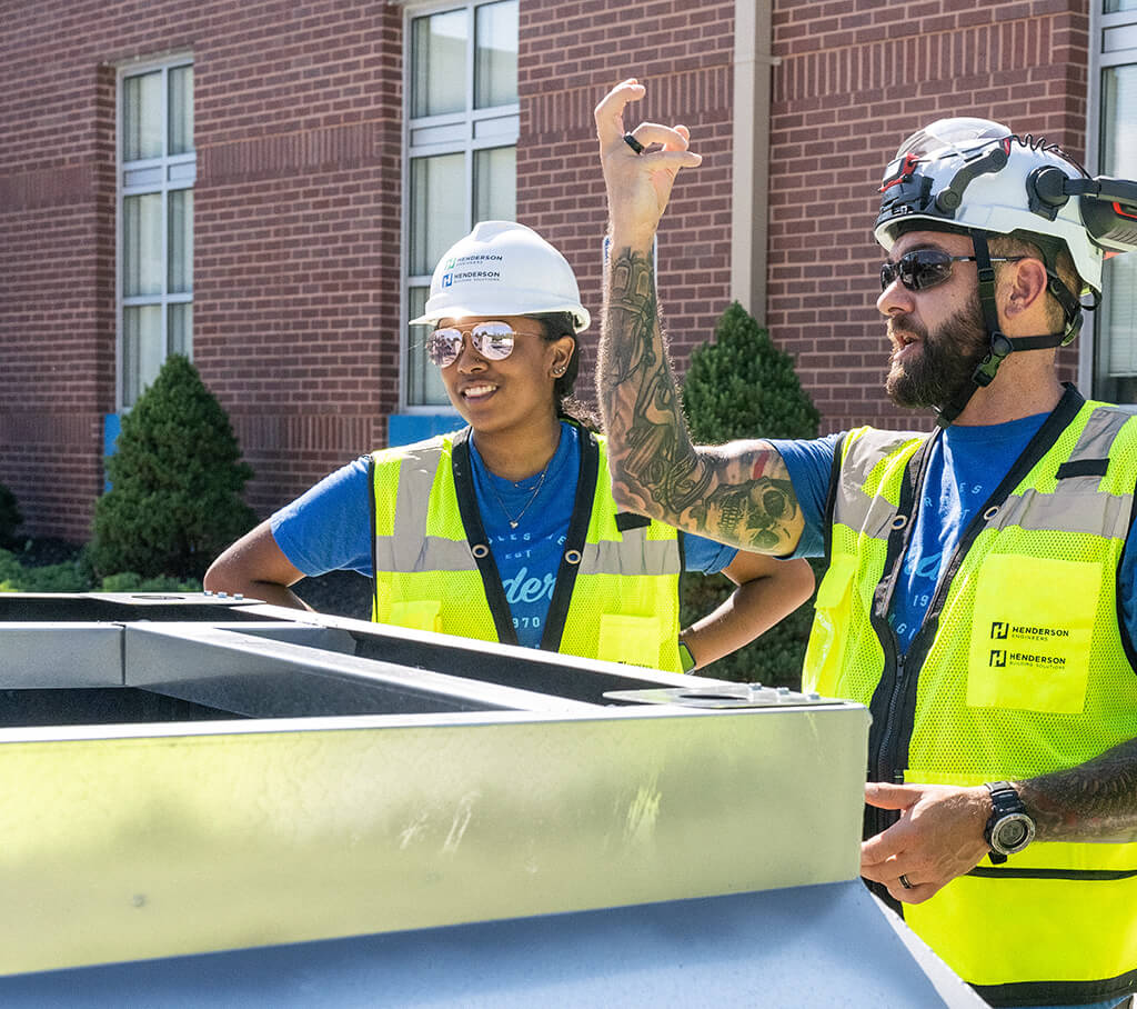 Two Henderson Building Solutions employees talking on a job site.