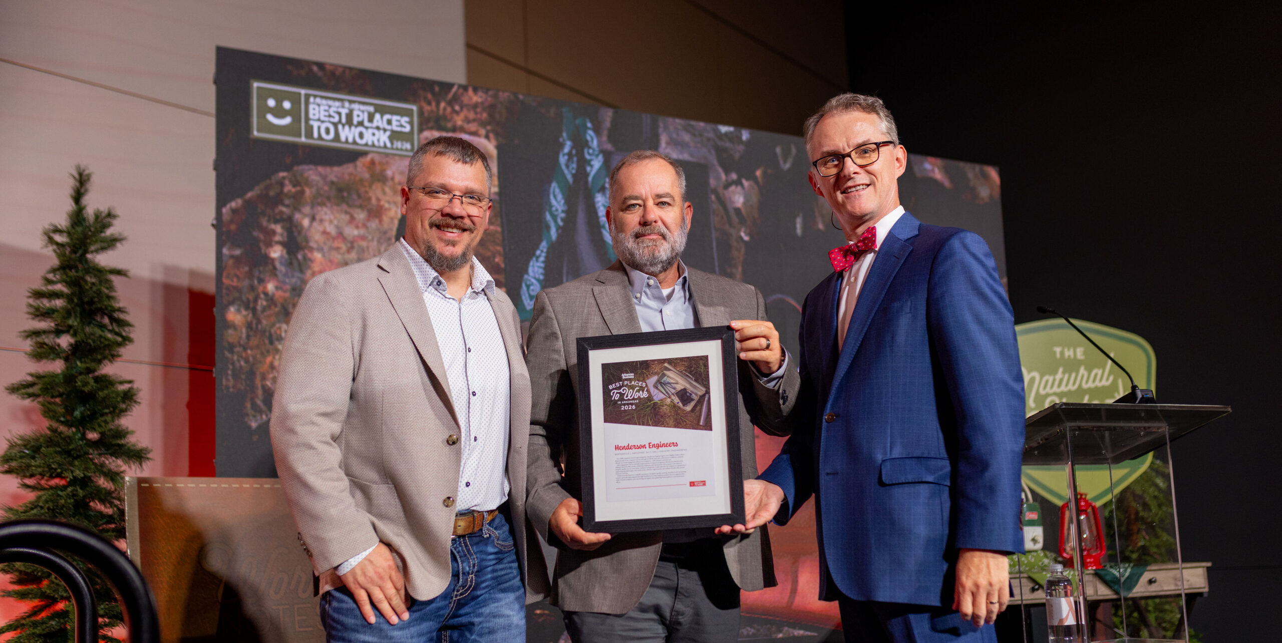 Photo of a Henderson Engineers representative accepting a plaque on stage.