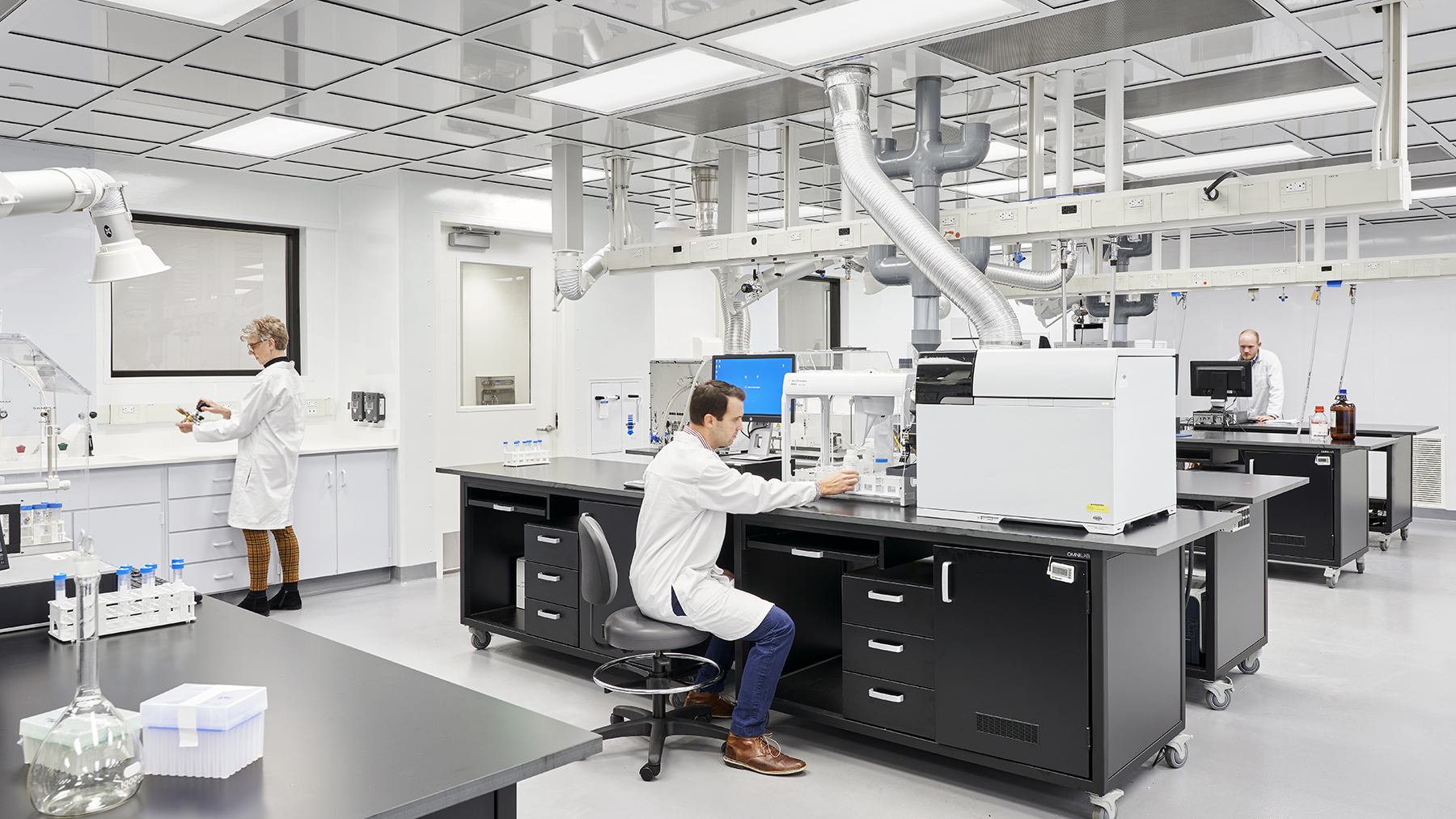 Interior of a laboratory with scientist working a different work stations.