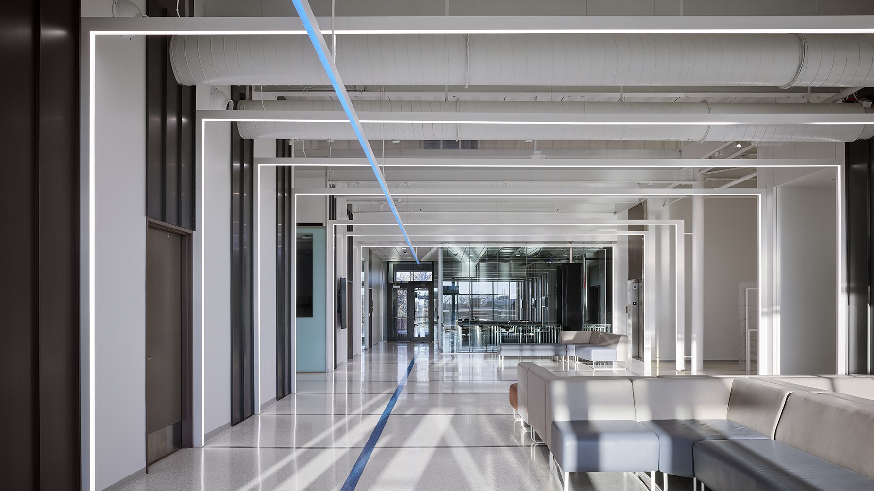 Interior of an entry lobby with lights and wires running on the ceiling.